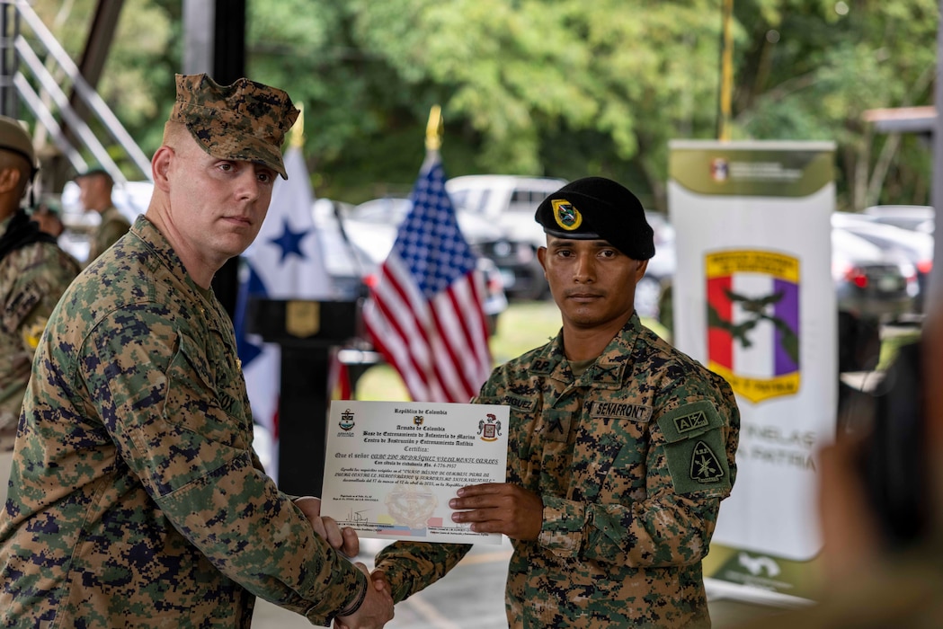 U.S. Marine Corps Maj. James Cox, regional affairs officer, Marine Corps Forces, South, awards a certificate of completion to personnel with the National Aeronaval Service of Panama during the graduation of the Basic Combat Training Counter Narcotics and Terrorism course in Panama, April 11, 2025. The U.S.-Colombia Action Plan pairs U.S. resources with Colombian expertise, with Colombian forces serving as the primary instructors for partner nation training programs across the region. (U.S. Marine Corps photo by Cpl. Samuel Qin)