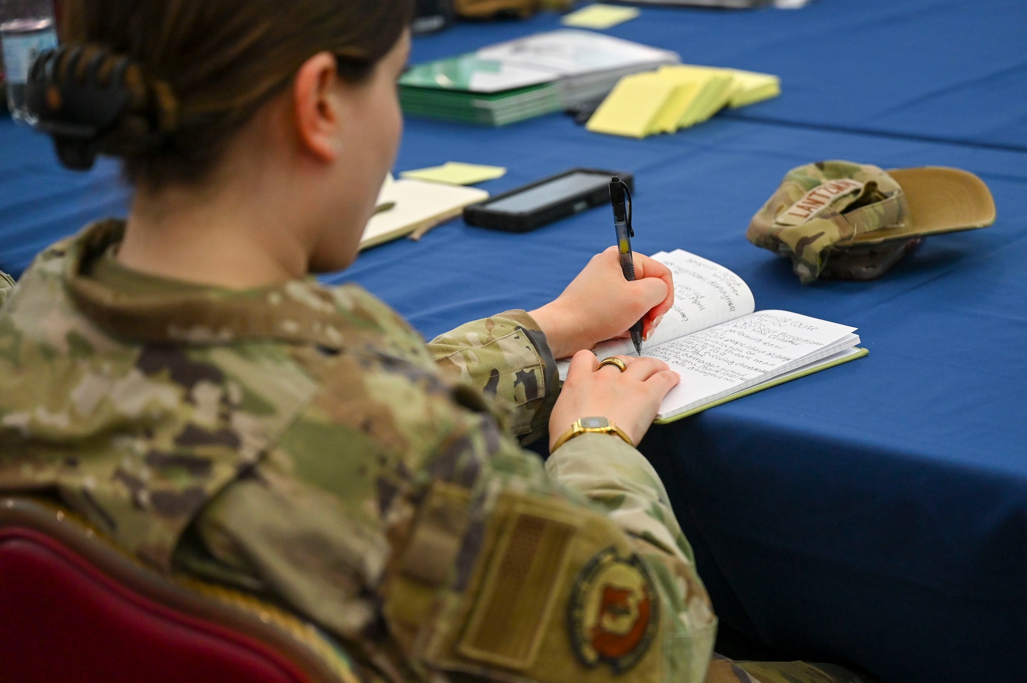 An airman writing in a notebook.