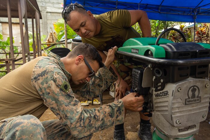 U.S. Marine Corps Staff Sgt. Paul Flores, a platoon sergeant with 1st Marine Aircraft Wing, and Philipine Air Force Sgt. Mark Jones Golfo an engineer with the 355th Air Engineering Wing inspect a compactor during Exercise Balikatan 25 at the Barangay Dagupan Multipurpose Gymnasium, Lal-lo, Cagayan, Philippines, April 8, 2025. Balikatan is a longstanding annual exercise between the Armed Forces of the Philippines and the U.S. military designed to strengthen our ironclad alliance, improve our capable combined force and demonstrate our commitment to regional security and stability (U.S. Marine Corps photo by Lance Cpl. Roger- Junior Annoh)