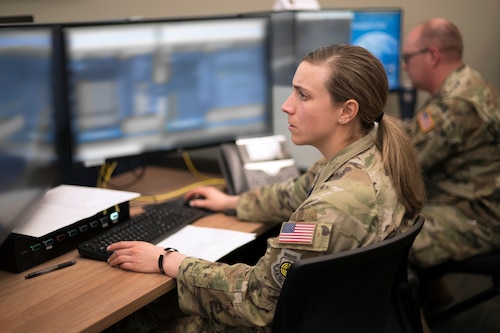 Woman in uniform at desk.
