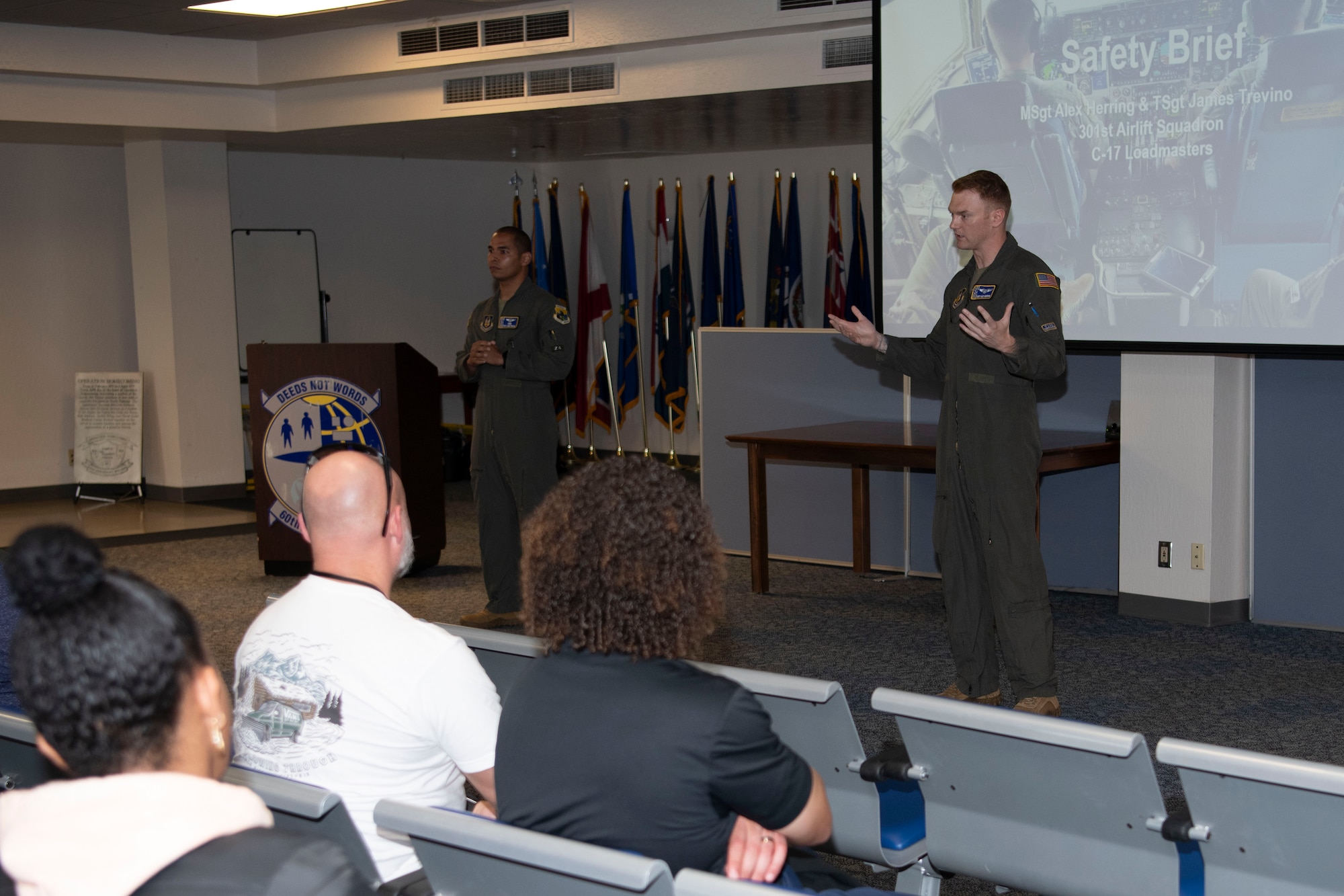 Airmen on stage briefing to crowd members.