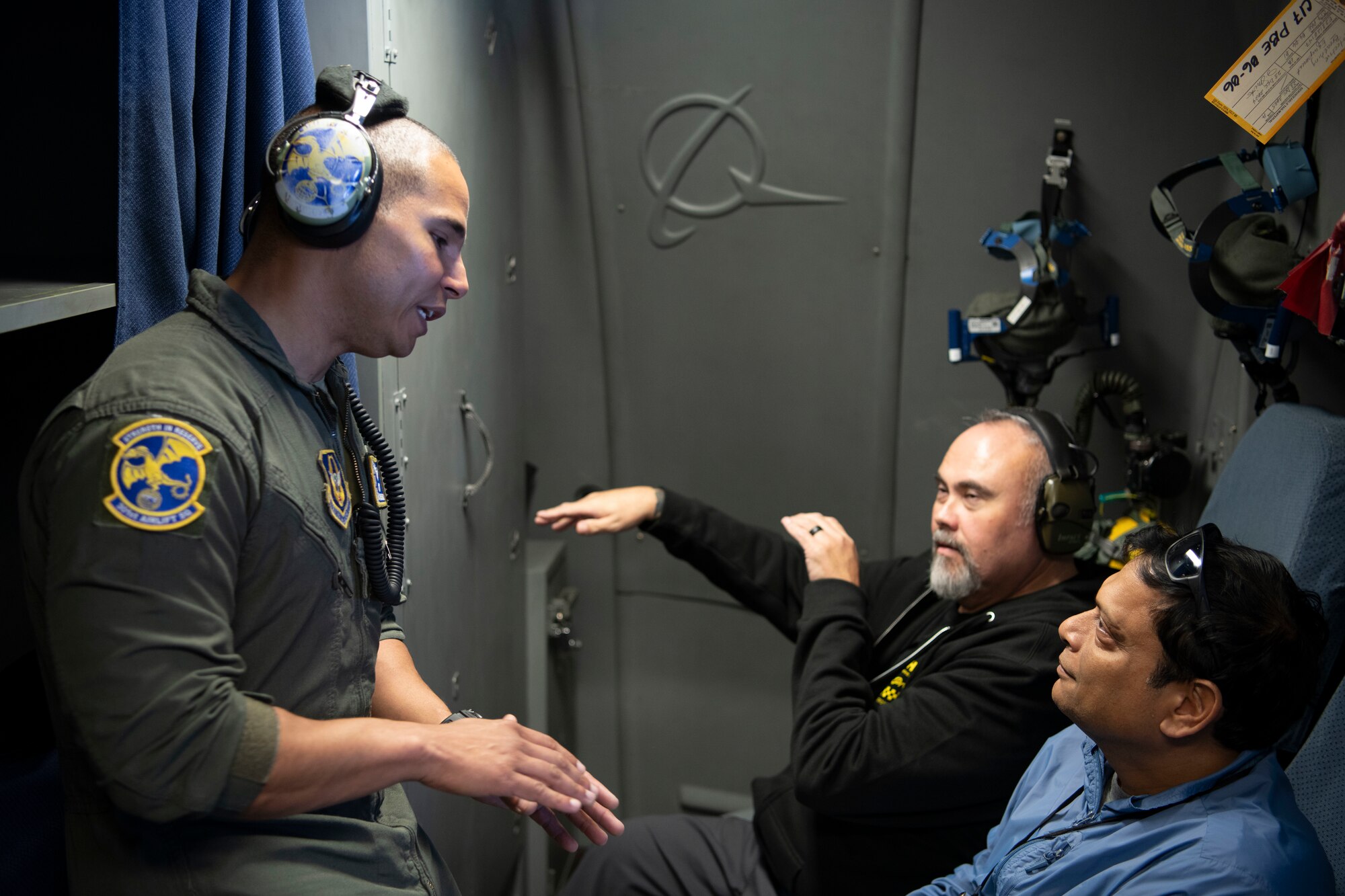 Spouses sitting together speaking with an aircrew member while on flight.