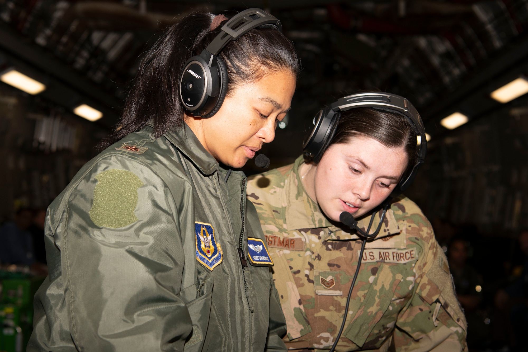 Two Airmen standing side by side honing their skills during a spouse flight.