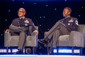 Two military members speak at a symposium.