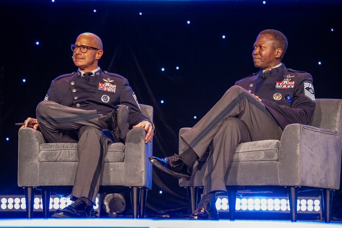 Two military members speak at a symposium.