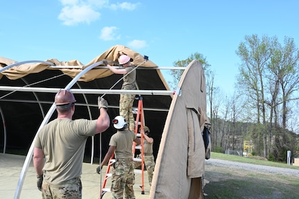 Airmen assigned to the 175th Wing, Maryland Air National Guard, construct a small shelter system at the 145th Regional Training Site in Badin, North Carolina, April 4, 2025.