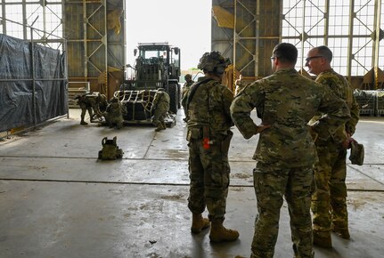 Lt. Gen. John Healy stands next to Airmen
