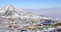 The vast land of the Antarctic has snow and lots of buildings.