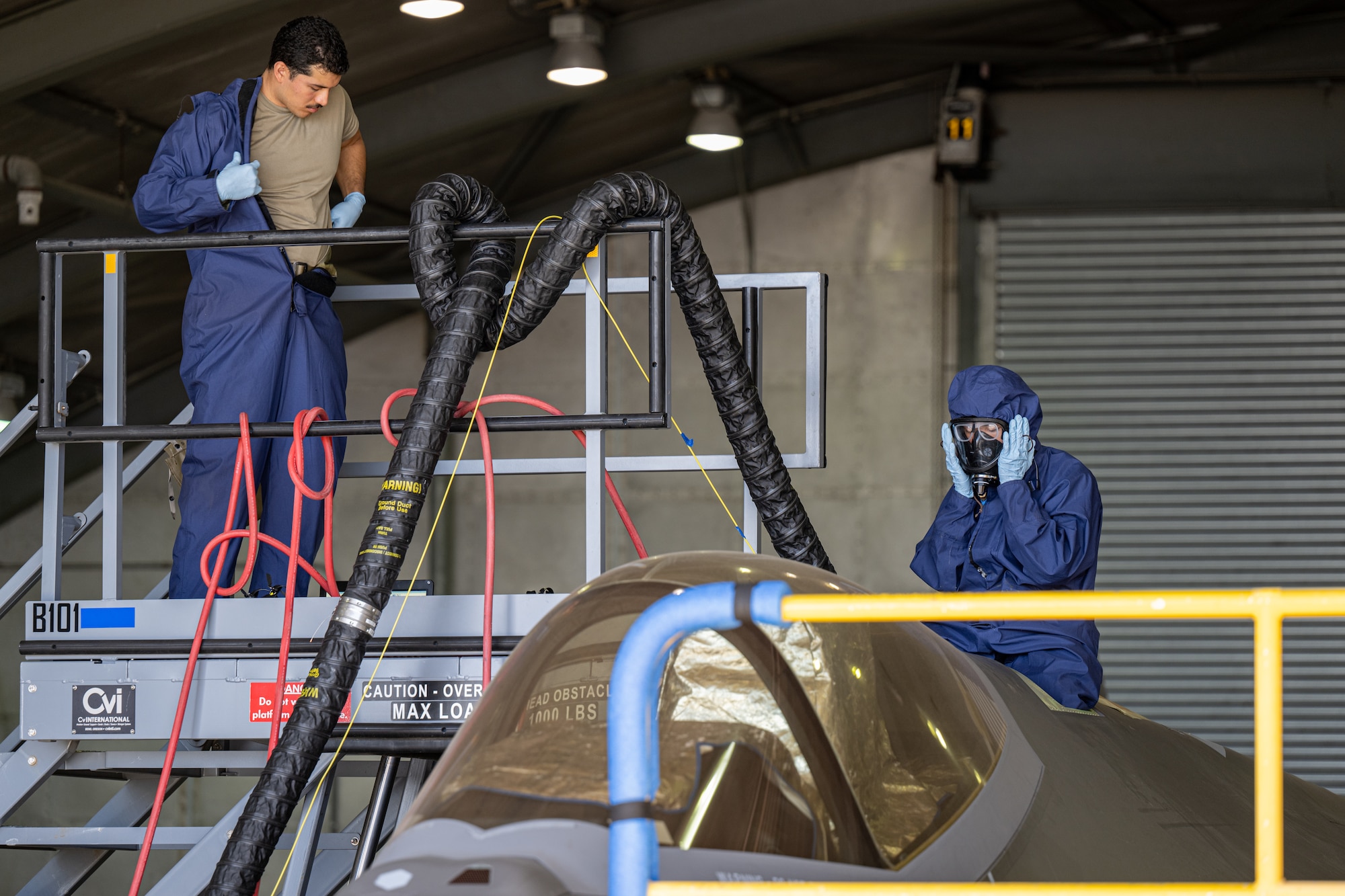Airmen don personal protective gear
