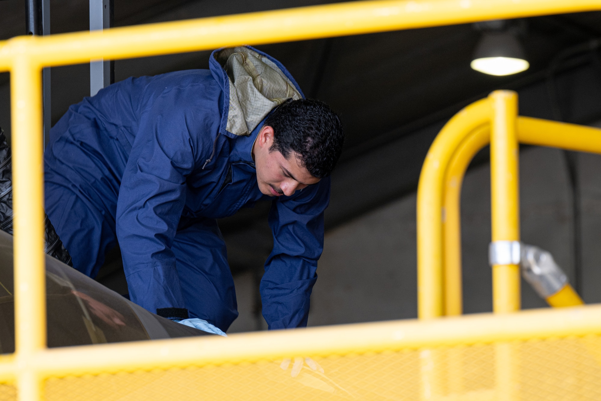 An Airman investigates an aircrafts fuselage