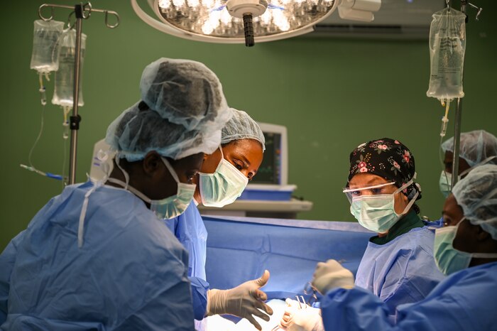 U.S. Air Force Tech. Sgt. Jocelyn Raymundo Grinstead (center right), a 433rd Medical Squadron lead surgical technician, assists Dr. Natalie Osborne (center left), a Kittitian general surgeon, during a surgical procedure to repair a hernia at Joseph N. France General Hospital in Basseterre, St. Kitts and Nevis, March 27, 2025.