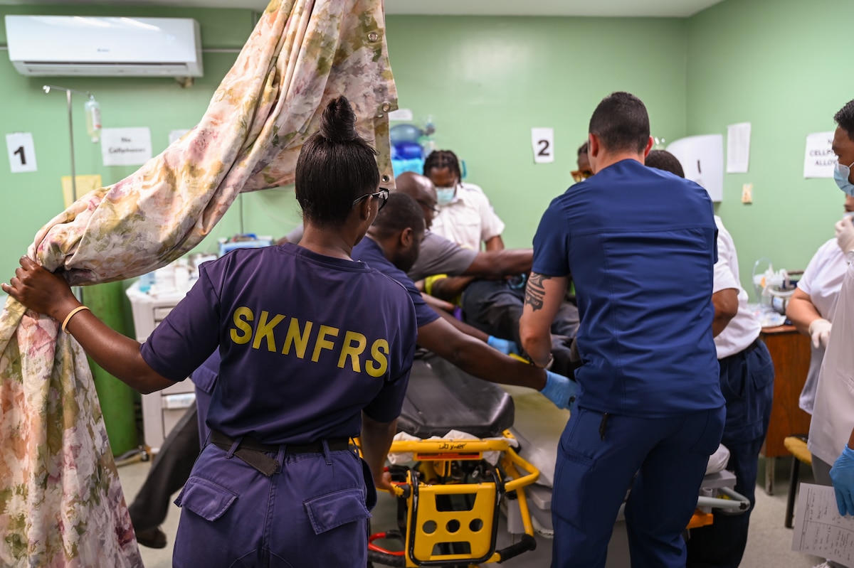 U.S. Air Force Capt. Thomas Murph, 433rd Medical Squadron emergency room nurse, assists Kittitian first responders at Joseph N. France General Hospital in Basseterre, St. Kitts and Nevis to move a man injured after a fall April 1, 2025.