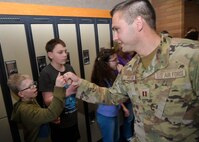 (Right) Capt. Aaron Peters, 75th Civil Engineer Squadron, fist-bumps junior high school students during a military parade April 11, 2025, at Syracuse Junior High School in Syracuse, Utah. Active-duty military from Hill Air Force Base and local veterans participated in the parade, which aimed to celebrate military families during Month of the Military Child in April. (U.S. Air Force photo by Todd Cromar)