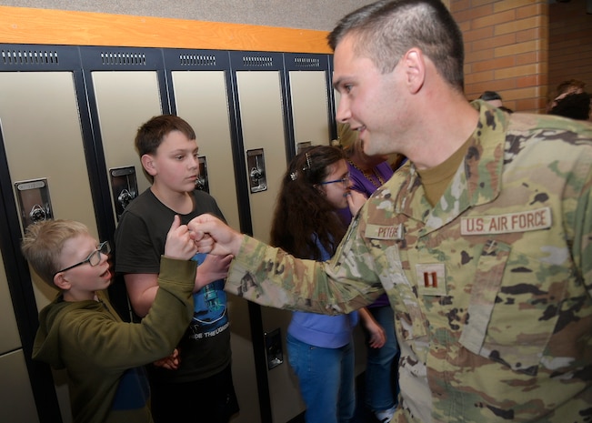 (Right) Capt. Aaron Peters, 75th Civil Engineer Squadron, fist-bumps junior high school students during a military parade April 11, 2025, at Syracuse Junior High School in Syracuse, Utah. Active-duty military from Hill Air Force Base and local veterans participated in the parade, which aimed to celebrate military families during Month of the Military Child in April. (U.S. Air Force photo by Todd Cromar)