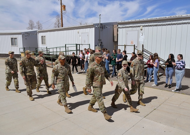 Hill Air Force Base Airmen wave to students during a military parade April 11, 2025, at Syracuse Junior High School in Syracuse, Utah. Active-duty military from Hill Air Force Base and local veterans participated in the parade, which aimed to celebrate military families during Month of the Military Child in April. (U.S. Air Force photo by Todd Cromar)