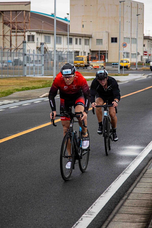 U.S. Marine Corps Master Sgt. Kenneth Jacob, an ordnance chief with Marine Fighter Attack Squadron 121 (VMFA 121), 1st Marine Aircraft Wing, and a native of Ohio, and a Japanese participant, complete the 12k bike ride portion of the 36th Marine Corps Air Station Iwakuni Sprint Triathlon at MCAS Iwakuni, Japan, April 13, 2025. The triathlon included a 350-meter swim, 12-kilometer bike ride, and 4.5-kilometer run, and was held to strengthen relationships between U.S. and Japanese personnel through friendly competition. (U.S. Marine Corps photo by Lance Cpl. Rylan Adcock)