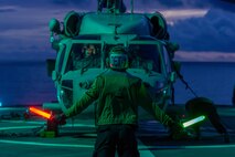 Aviation Electronics Technician 3rd Class Trevor Bailey, from Post Fall, Idaho, assigned to the “Golden Falcons” of Helicopter Sea Combat Squadron (HSC) 12 communicates with the pilots of an MH-60S Seahawk helicopter during flight operations aboard the U.S. 7th Fleet flagship USS Blue Ridge (LCC 19) while underway in the Coral Sea, April 11, 2025.