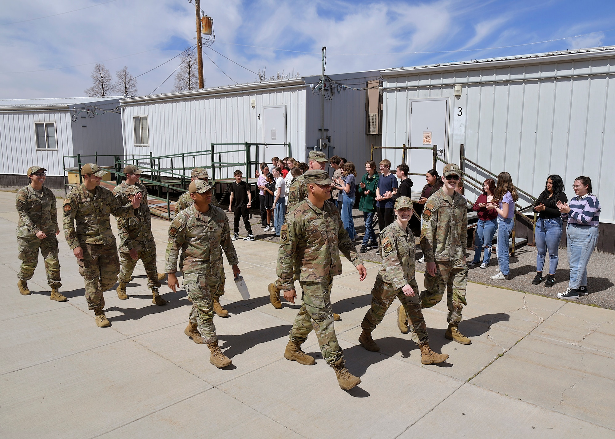 Hill Air Force Base Airmen wave to students during a military parade April 11, 2025, at Syracuse Junior High School in Syracuse, Utah. Active-duty military from Hill Air Force Base and local veterans participated in the parade, which aimed to celebrate military families during Month of the Military Child in April. (U.S. Air Force photo by Todd Cromar)