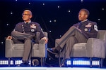 Two military members speak at a symposium.
