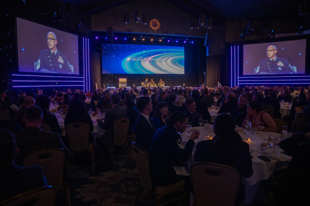 Military members speak at a symposium.