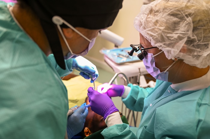 U.S. Air Force Lt. Col. Jessica Harvey (right), 433rd Medical Squadron dentist, and Master Sgt. Carmen Depaola (left), 349th Aerospace Medicine Squadron dental technician, repair a patient’s chipped tooth at Pogson Dental Clinic on St. Kitts and Nevis, April 1, 2025.