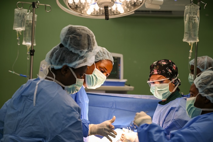 U.S. Air Force Tech. Sgt. Jocelyn Raymundo Grinstead (center right), a 433rd Medical Squadron lead surgical technician, assists Dr. Natalie Osborne (center left), a Kittitian general surgeon, during a surgical procedure to repair a hernia at Joseph N. France General Hospital in Basseterre, St. Kitts and Nevis, March 27, 2025.