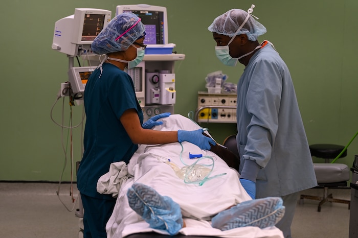 U.S. Air Force Staff Sgt. Daisy Victoria (left), 433rd Medical Squadron surgical technician, and Capt. Albert Scott (right),  433rd Medical Squadron certified registered nurse anesthetist, prepare to move a patient following a procedure at Joseph N. France General Hospital in Basseterre, St. Kitts and Nevis, March 27, 2025.