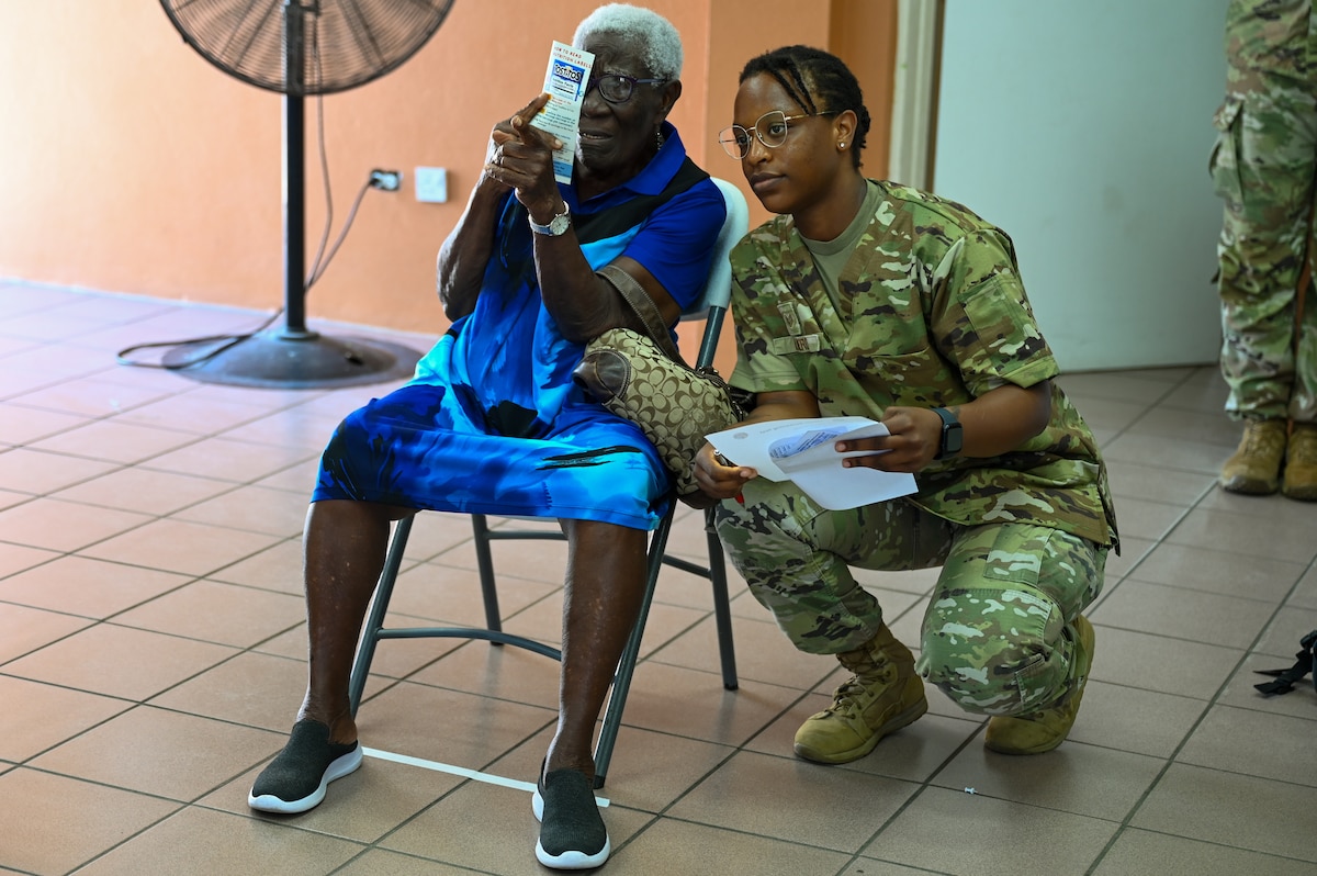 U.S. Air Force Staff Sgt. Desiree Cubero (center), 433rd Medical Squadron medical technician, administers a vision screening to a Kittitian woman during a health fair at the Newtown Community Center as part of the Lesser Antilles Medical Assistance Team (LAMAT) 2025 in St. Kitts and Nevis, April 2, 2025.