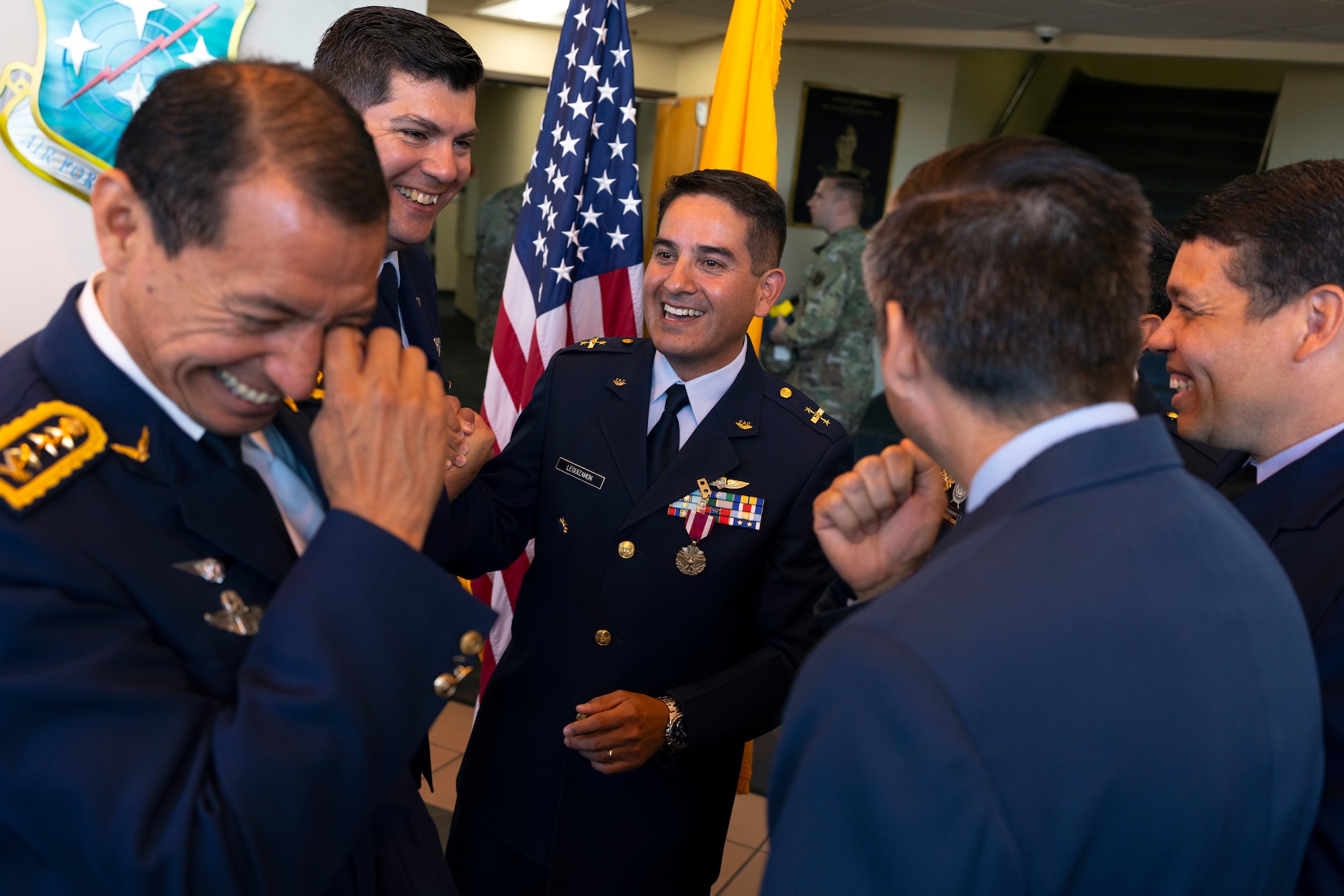 Colombian Air Force Col. Alejandro Leguizamón, Air Forces Southern foreign liaison officer, center, shares a lighthearted moment with cohorts at Davis-Monthan Air Force Base, Arizona, March 25, 2025. Foreign liaison officers serve as vital conduits between partner nations and U.S. military organizations, helping foster trust, enhance interoperability and coordinate joint efforts in pursuit of shared defense goals. (U.S. Air Force Photo by Tech. Sgt. Rachel Maxwell)