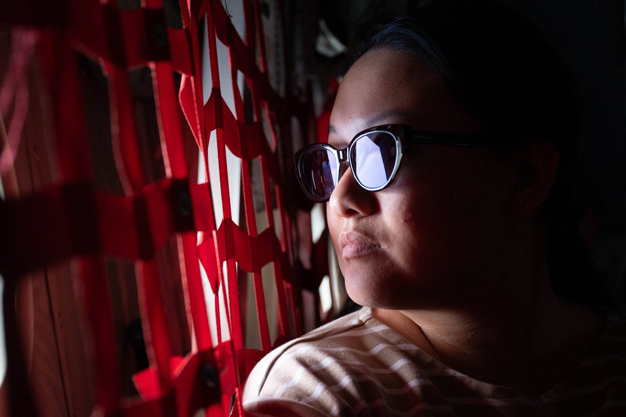 A woman looks out the window of an MC-130J.