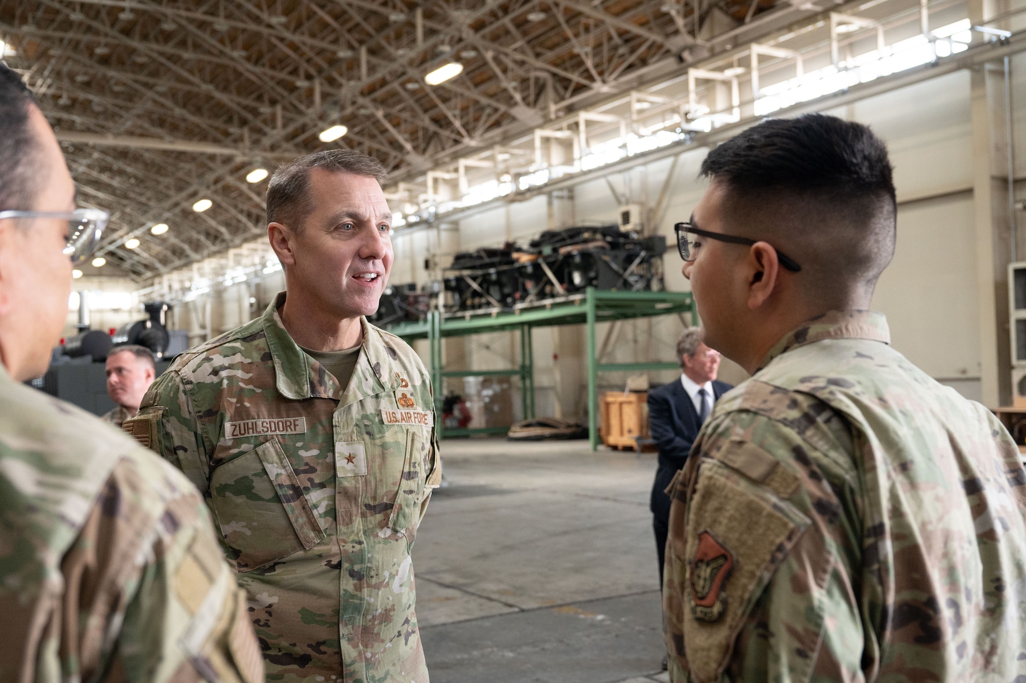 Two service members speak in a hangar