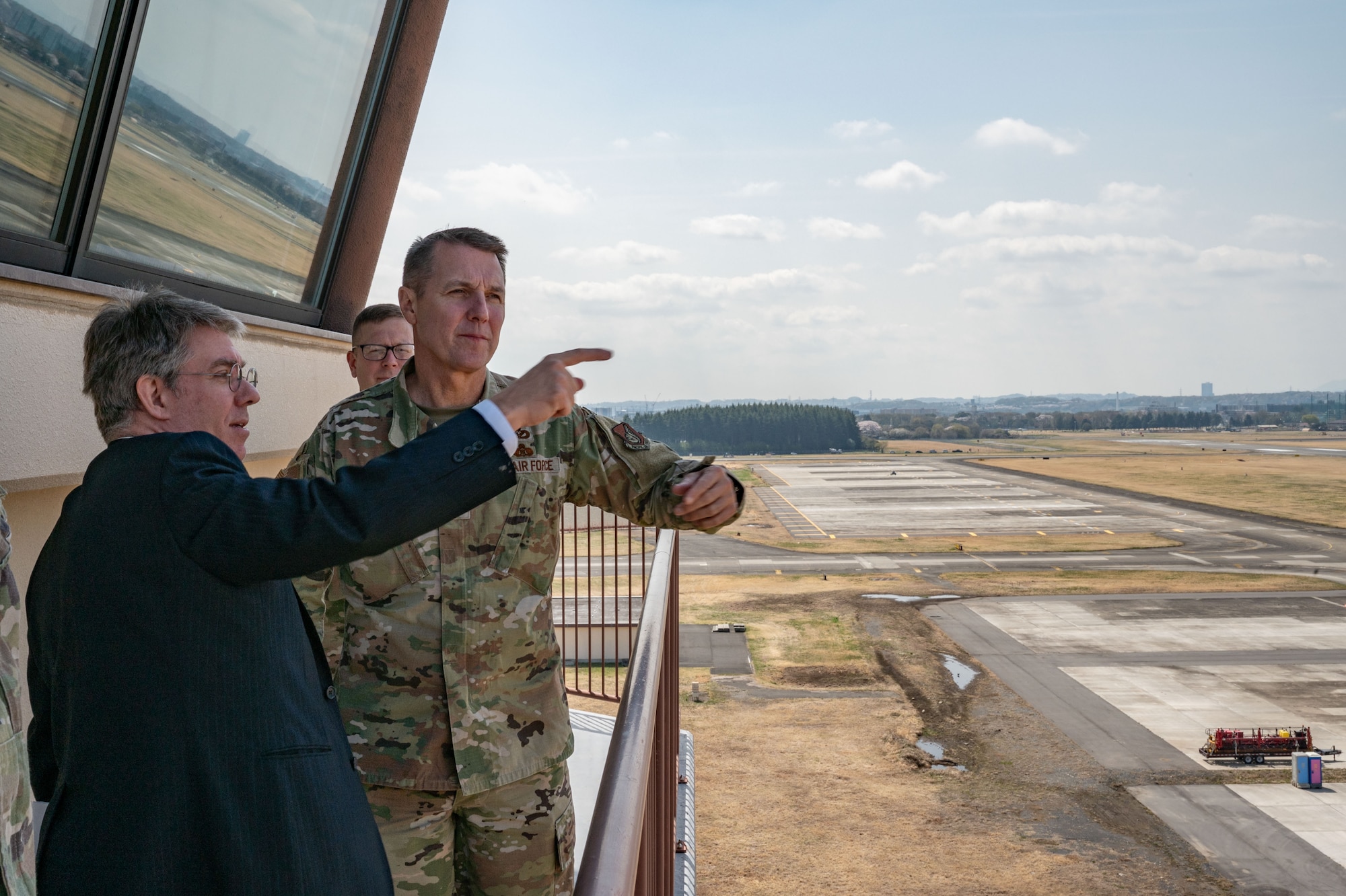 Service members and personnel overlook an airfield