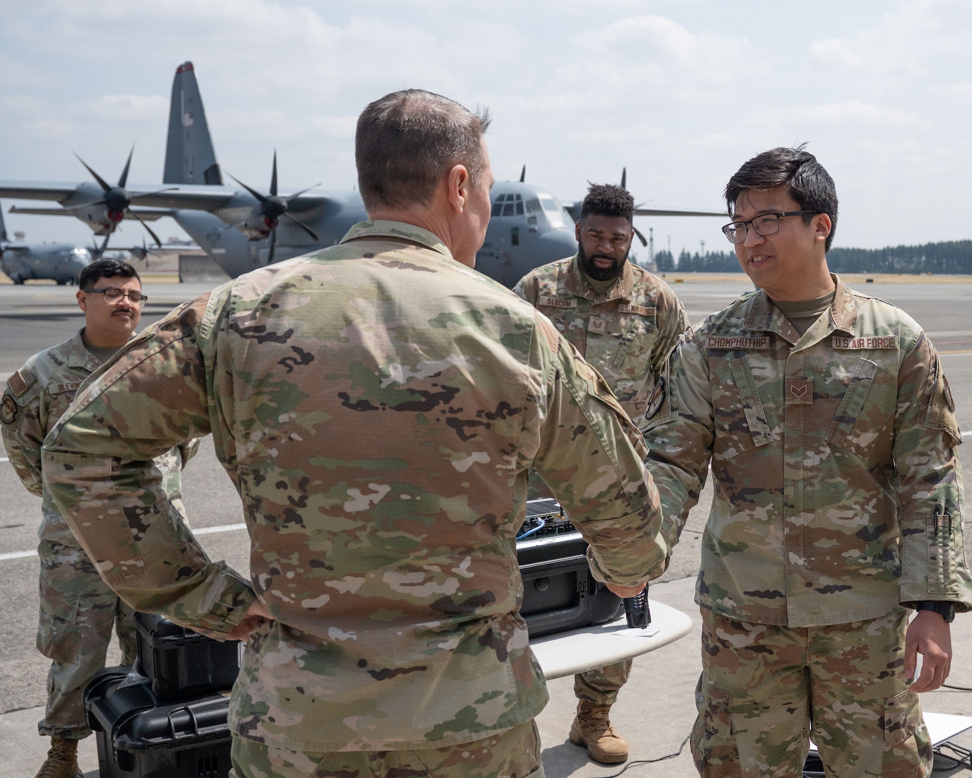 A service member shakes another service members hand