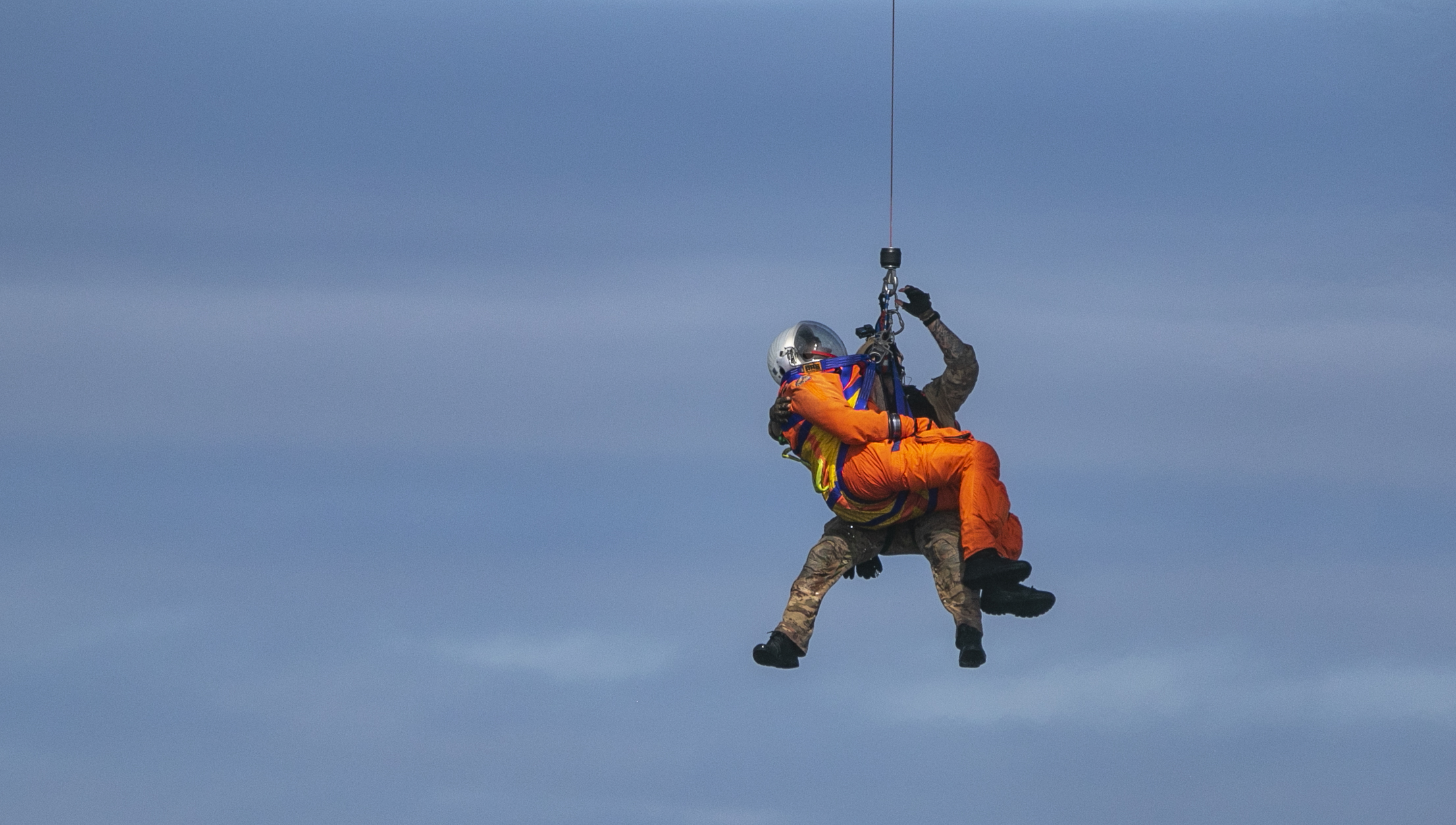 Hospital Corpsman 2nd Class Christian Richter, assigned to Helicopter Sea Combat Squadron 23 “Wild Cards,” and a NASA astronaut hoist into an MH-60S Seahawk during NASA Underway Recovery Test 12 in the Pacific Ocean, March 27, 2025. In preparation for NASA's Artemis II crewed mission, which will send four astronauts around the Moon and beyond in the Orion spacecraft, NASA and the Department of Defense will conduct a series of tests to demonstrate and evaluate the processes, procedures, and hardware used in recovery operations for crewed lunar missions. The Department of Defense has many unique capabilities that make it an ideal partner to support NASA, including its amphibious ships with the ability to embark helicopters, launch and recover small boats and provide medical care at advanced onboard facilities. (U.S. Navy photo by Mass Communication Specialist 2nd Class Nettie Mae Manfull)