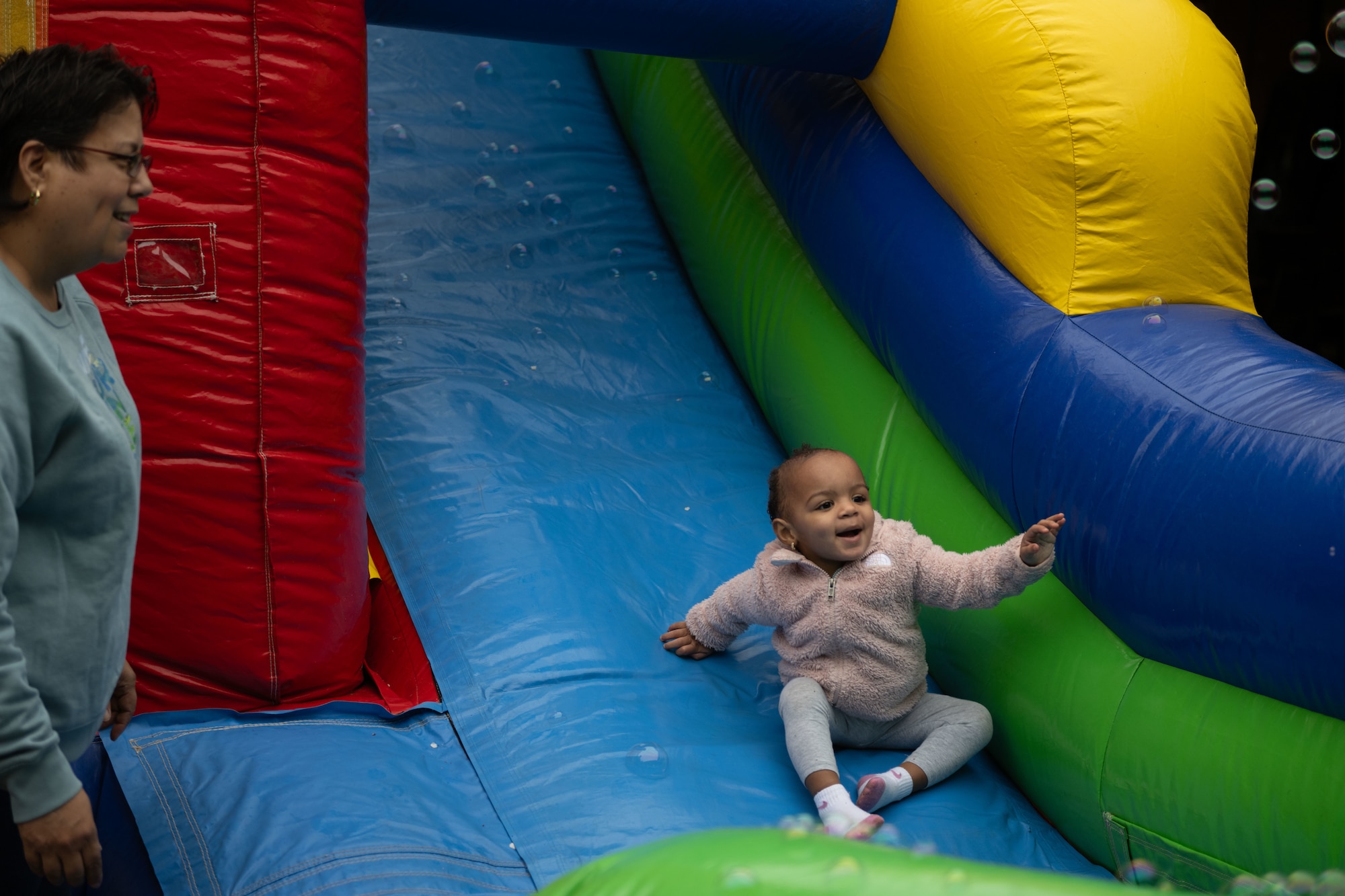 Child slides down bounce house during Adaptive Field Day.