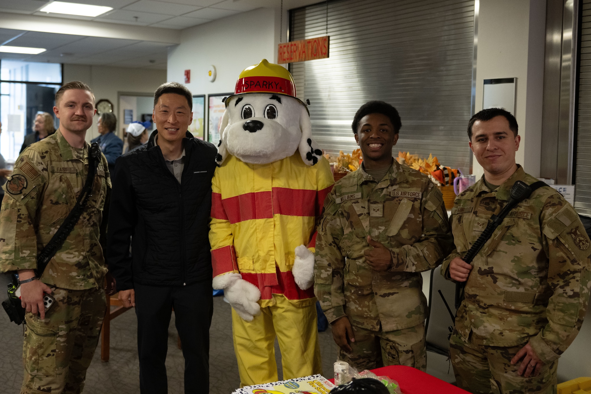 Firefighters pose for photo with mascot and commander.