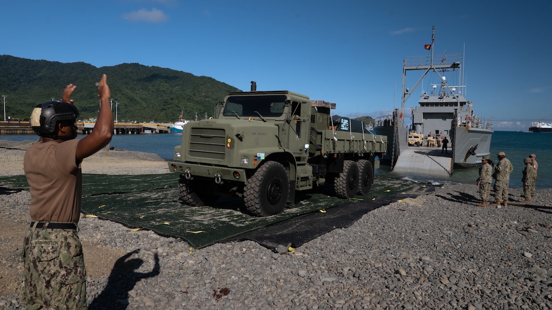 A U.S. Navy Medium Tactical Vehicle Replacement tests the stability of the ramp of the U.S. Army vessel Palo Alto (LCU-2032) before unloading equipment to the shore during the combined joint over-the-shore operations in preparation for Exercise Balikatan 25 in Dingalan, Philippines, April 8, 2025. Balikatan is a longstanding annual exercise between the Armed Forces of the Philippines and U.S. military designed to strengthen our ironclad alliance, improve our capable combined force, and demonstrate our commitment to regional security and stability. (U.S. Marine Corps photo by Cpl. Brian Knowles)