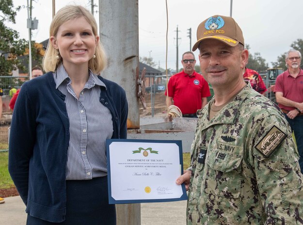 Ms. Anna Belle Tiller, NSWC PCD contracting officer, is presented the Dept. of the U.S. Navy's Civilian Service Achievement Medal by Capt. Paul Stence, Jr., NSWC PCD commanding officer, March 14. Her actions to ensure the fleet can continue receiving in-service engineering agent support on the unmanned surface vehicles being deployed as part of the mine countermeasure mission package on littoral combat ships resulted in cost savings of nearly $80M. (U.S. Navy photo by Eddie Green)