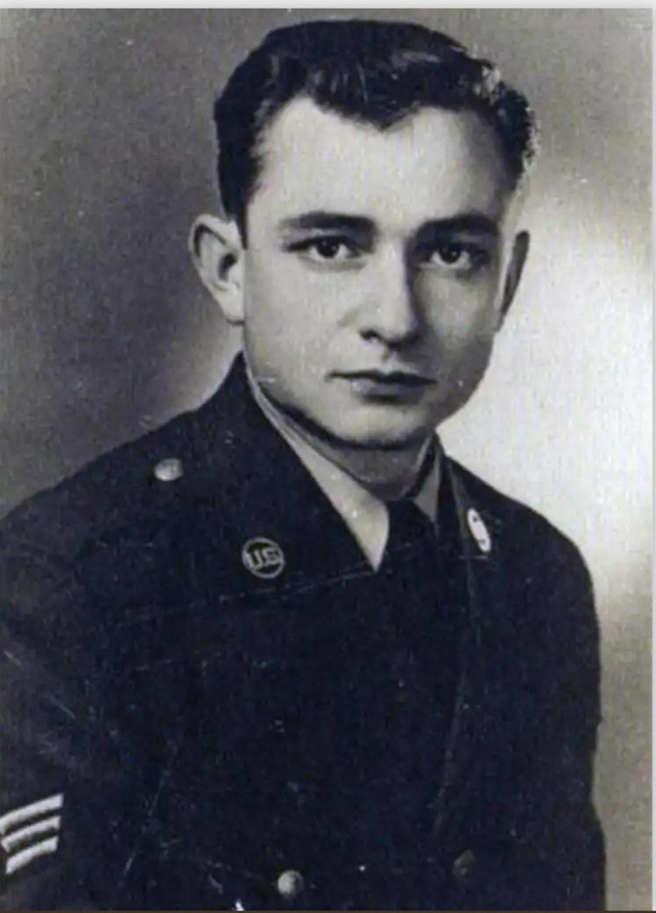 A man in a military uniform poses for a photo.