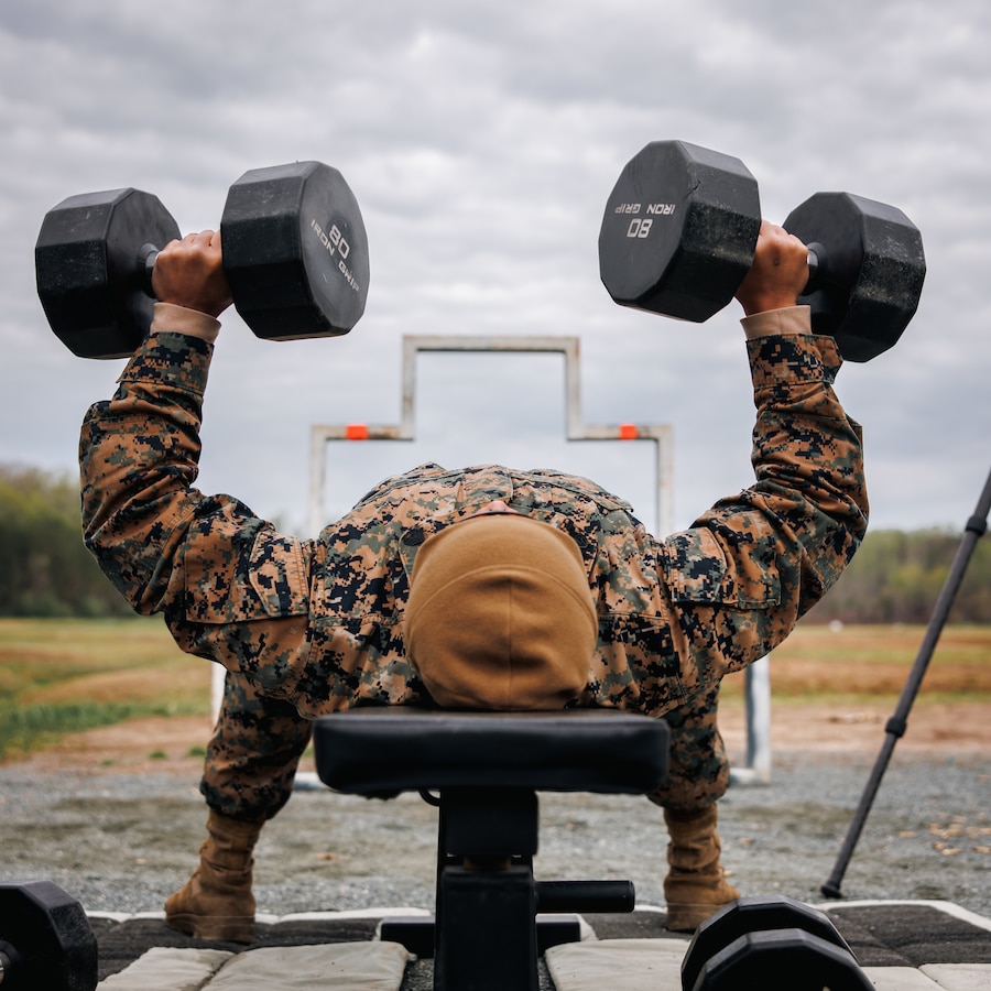 U.S. Marine Corps Staff Sgt. Seyha Lek, a motor transport instructor with Marine Corps Detachment Training Command Fort Leonard Wood, conducts a bench press as part of a shooting drill during the Marine Corps Marksmanship Championships individual rifle match, hosted by Weapons Training Battalion at Marine Corps Base Quantico, Virginia, April 14, 2025. The competition brings together the top shooters from regional Marine Corps Marksmanship Competitions to test their skills in precision rifle, action pistol, and multi-gun shooting. It continues the legacy of the Marine Corps shooting team, which has upheld marksmanship excellence since the early 1900’s and reinforces the Corps’ commitment to marksmanship as a core warfighting skill. (U.S. Marine Corps photo by Lance Cpl. Braydon Rogers)