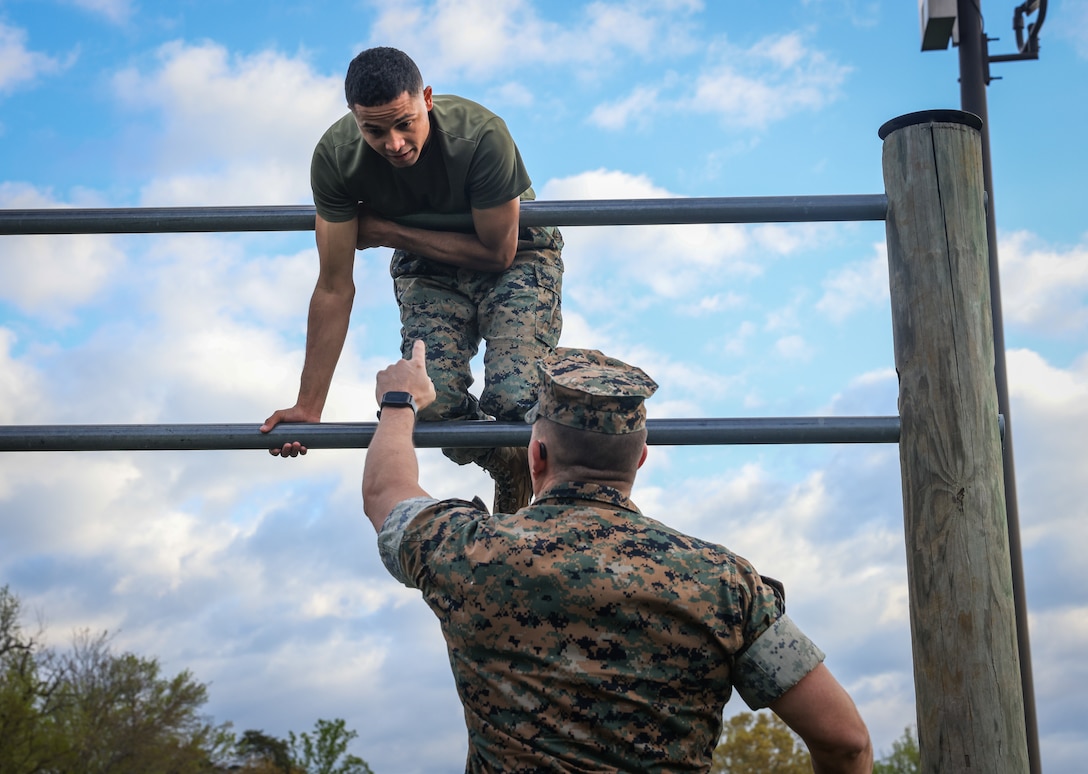 U.S. Marine Corps Cpl. Julio Calderon, a Color Bearer with Security Battalion’s Ceremonial Platoon receives instructional guidance from Lt. Col. Gerard VanderWaal, the commanding officer of Security Battalion, on how to complete an obstacle course on Marine Corps Base Quantico, April 16, 2025. Security Battalion hosted this PT event in order to foster Espirit de Corps. (U.S. Marine Corps photo by Lance Cpl. Jeffery Stevens)
