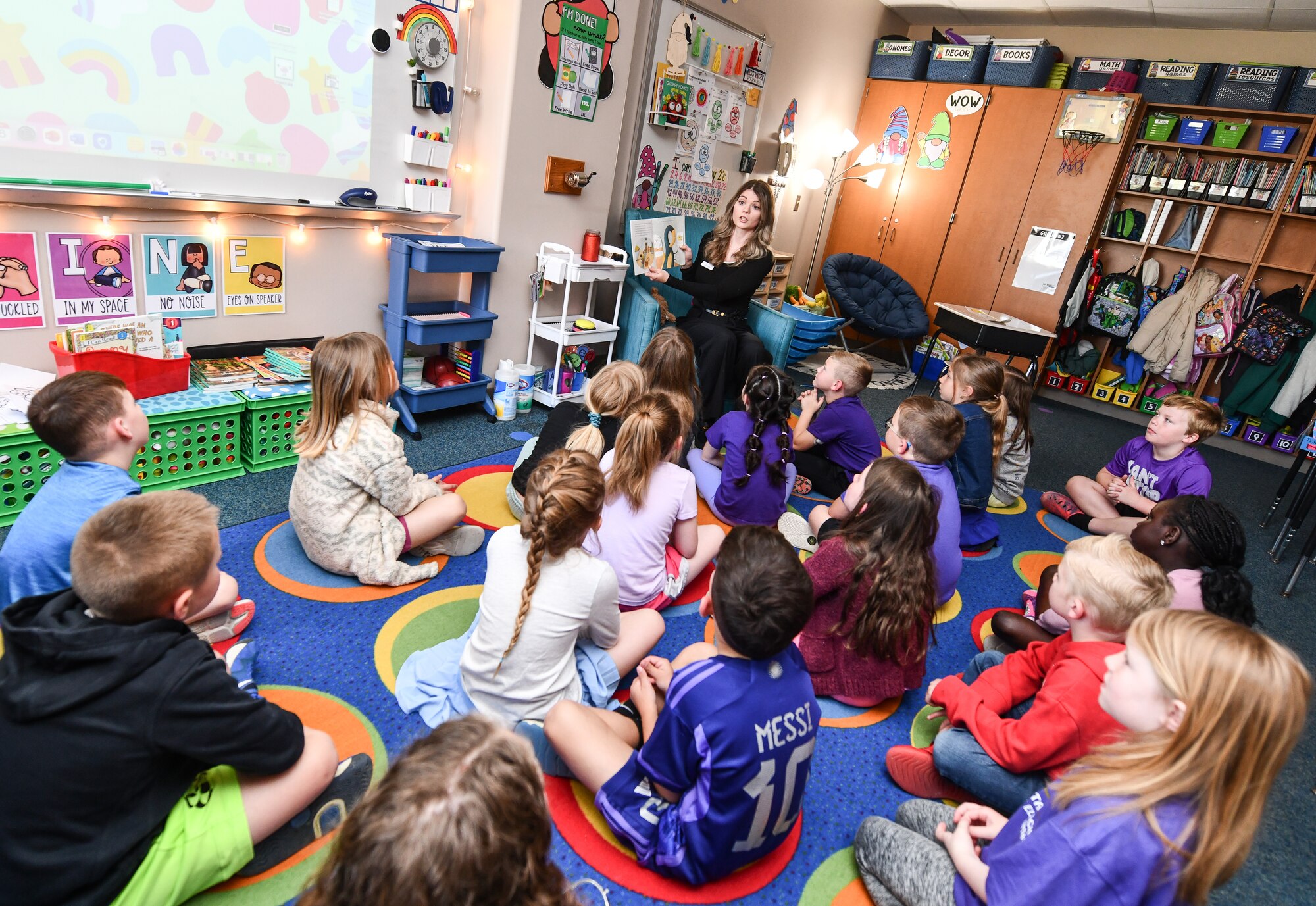 Joelle Mills, 55th Contracting Squadron contracting specialist, reads to Ms. Yurth's 2nd grade class at Patriot Elementary in La Vista, Nebraska, April 16, 2025. The event was part of the Month of the Military Child celebration, where service members read to school children. (U.S. Air Force photo by Chad Watkins)