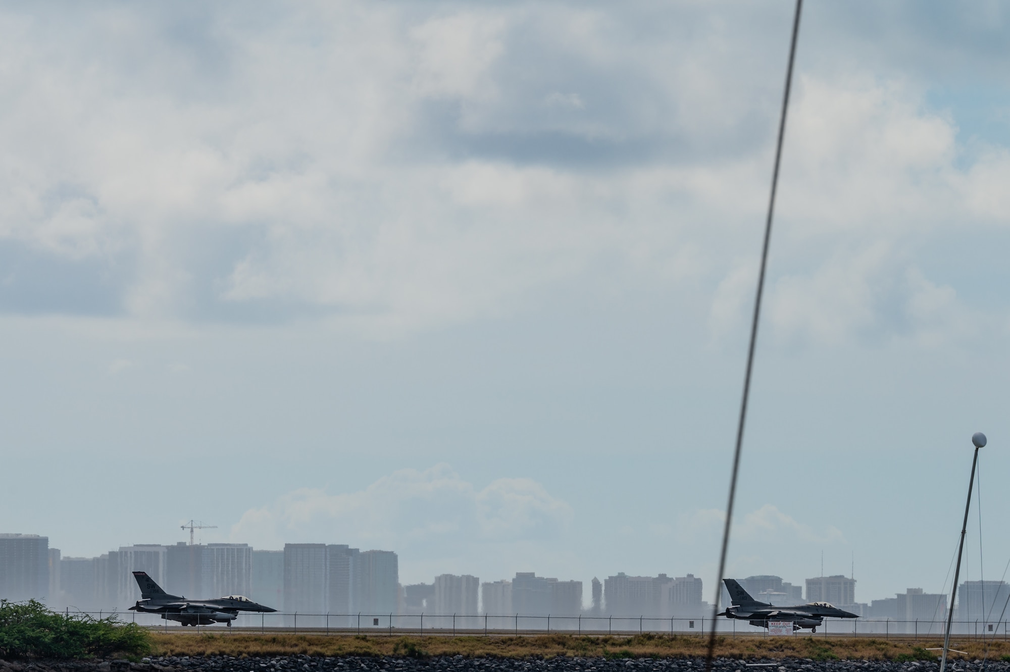 Two F-15 Eagles drive on the taxiway at the Honolulu Airport.