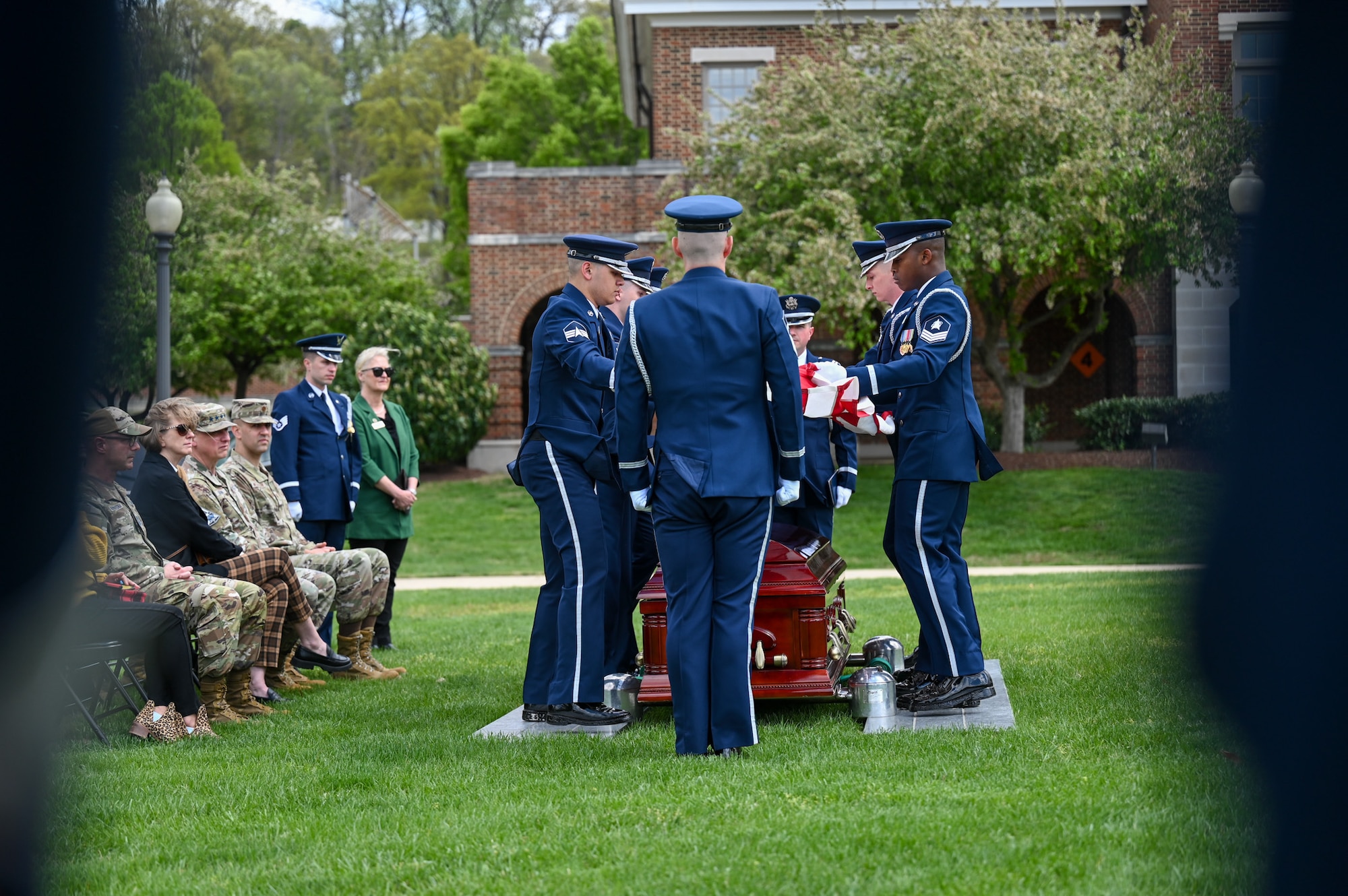 Photo of U.S. Space Force Honor Guard members performing a standard-honors funeral sequence for USSF leadership as they sit in attendance.