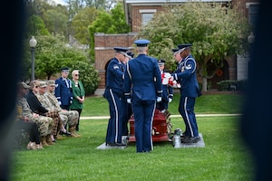 Photo of U.S. Space Force Honor Guard members performing a standard-honors funeral sequence for USSF leadership as they sit in attendance.
