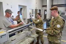 (From left) Darrel Gronau, aviation maintenance instructor, teaches metal forming and tool safety to ROTC Utah Military Academy students Cole Duffield, Alexandra Hyde and Max Richins March 11, 2025, at Hill Air Force Base, Utah. Local students learn, train and develop real-world airframe work skills by participating in local academic partnerships with the Hill Aerospace Museum’s established curriculum at the aircraft restoration facility. (U.S. Air Force photo by Todd Cromar)