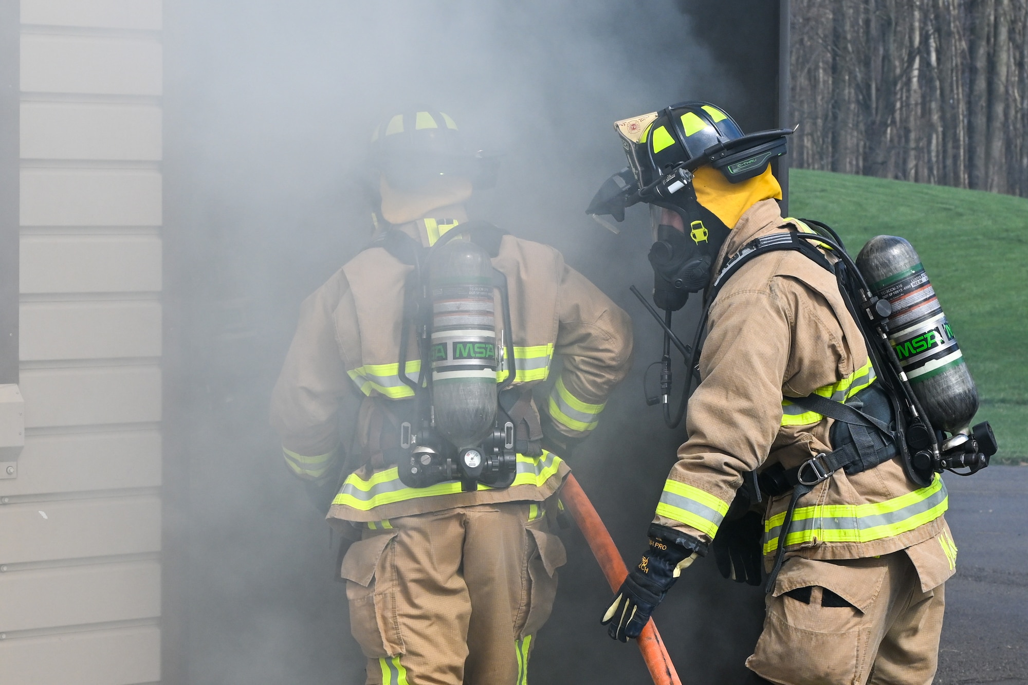 Youngstown Air Reserve Station firefighters enter a live-fire training building at the installation, April 7, 2025, while testing a new helmet-attached augmented reality system.