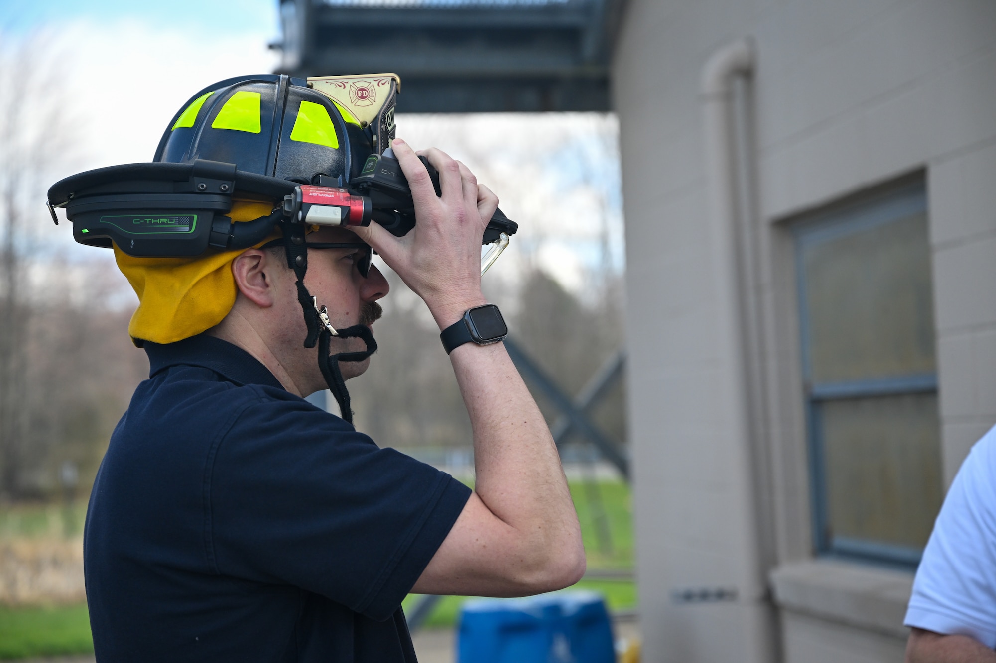 Justin Shultz, a firefighter with Youngstown Air Reserve Station's fire department, adjusts an augmented reality visor helmet attachment at YARS, Ohio, April 7, 2025.