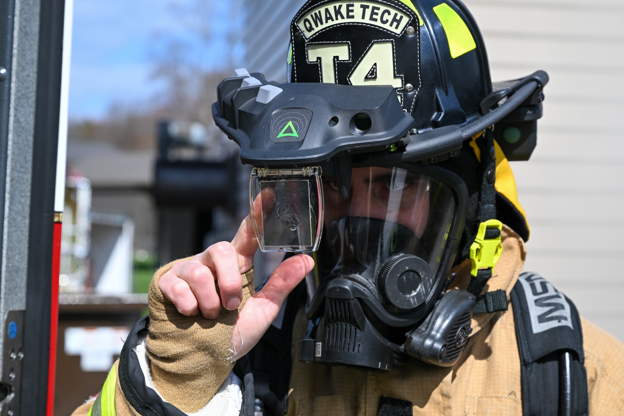 A firefighter equipped with an augmented reality helmet attachment system preps a hose before responding to a live-fire training event at YARS, Ohio, April 7, 2025.