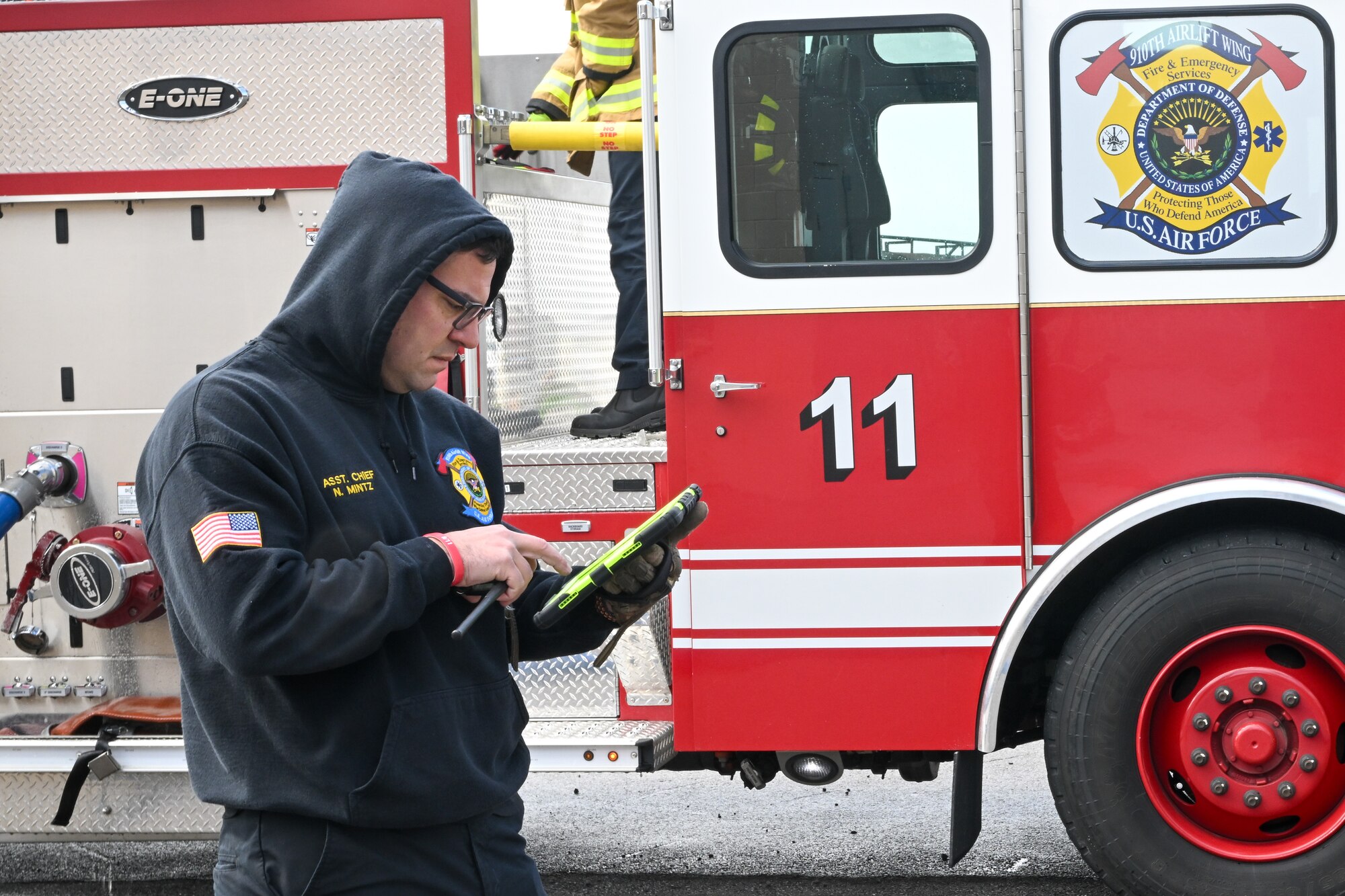 Nick Mintz, assistant fire chief, watches video feeds from augmented reality helmet attachment systems employed by firefighters during a live-fire training event at Youngstown Air Reserve Station, Ohio, April 7, 2025.